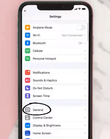 A smartphone screen showing the device settings menu, with the "General" option highlighted for iOS and "Apps" or "Application Manager" highlighted for Android.