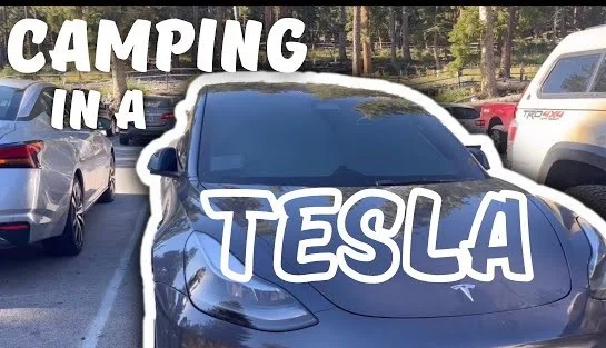 Tesla parked in a scenic camping location, with Camp Mode activated for a cozy and comfortable stay