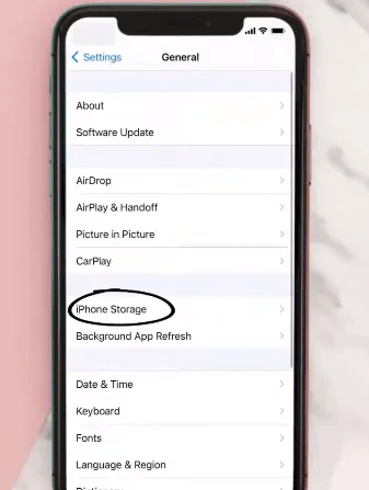 A smartphone screen showing the device settings menu, with the "General" option highlighted for iOS and "Apps" or "Application Manager" highlighted for Android.