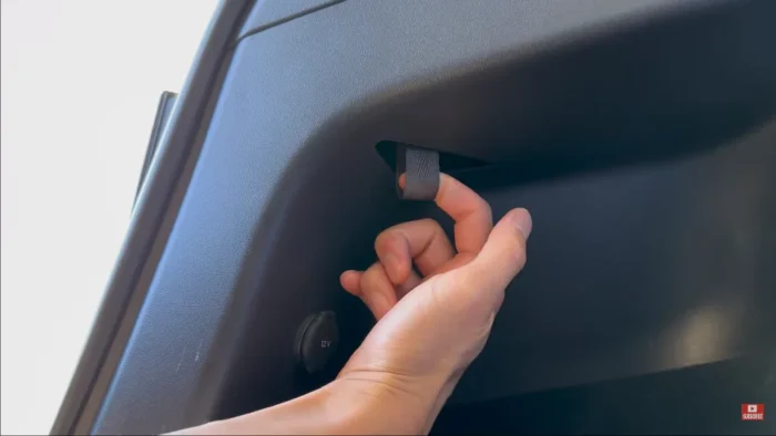 Tesla charge port being manually unlocked inside the trunk.