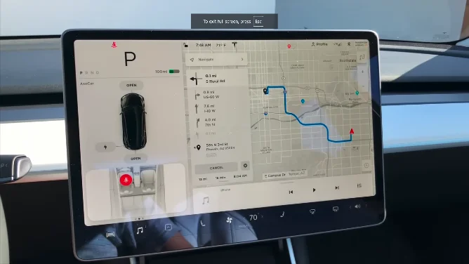 Tesla touchscreen showing navigation input and map display for current location.