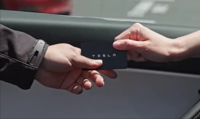 A Tesla key card being handed to the valet for use