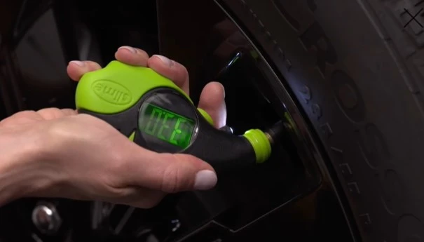 hand checking tire pressure