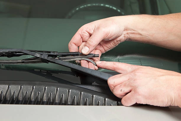 mechanics hand holding broken windshield wipers