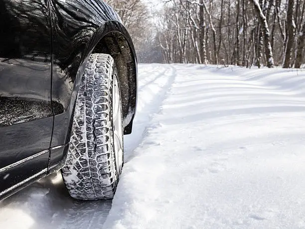 Driving SUV car in winter on forest road with much snow