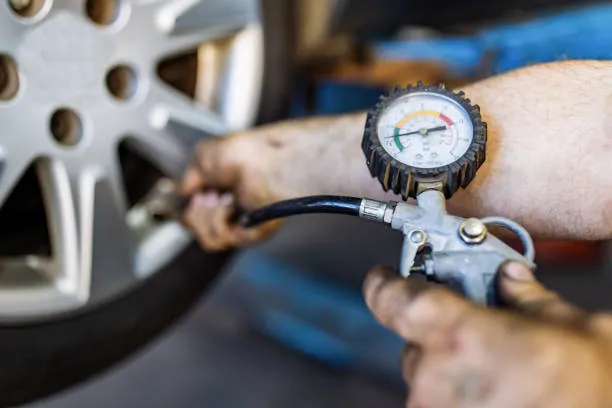 Man's hand checking tyre pressure.